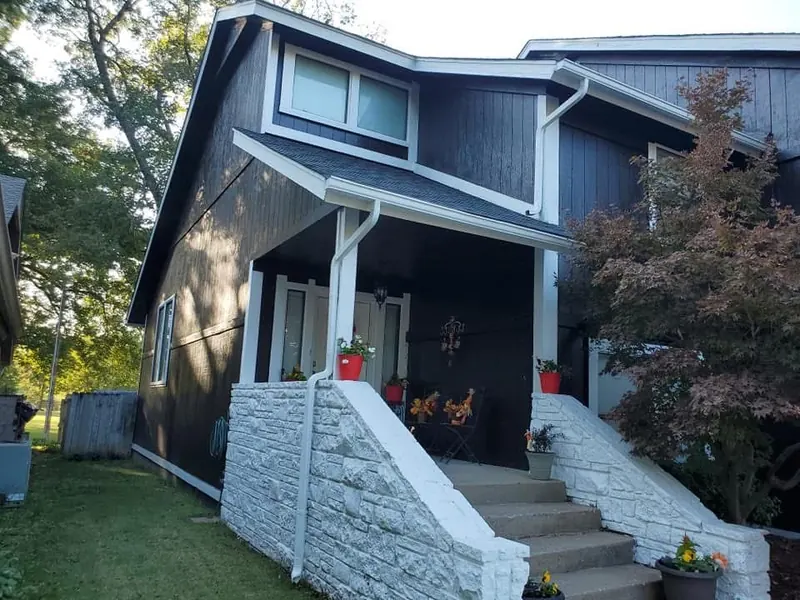 Home exterior with dark siding and white trim