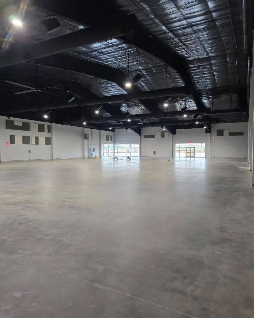 Large commercial interior with high black ceiling and polished concrete floor